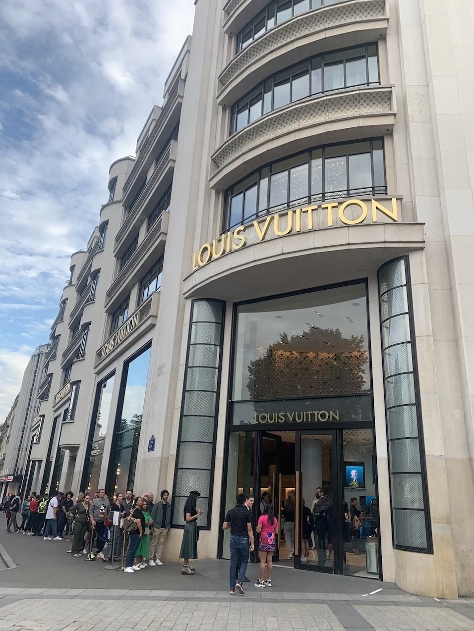 Queue of shoppers outside Louis Vuitton store on Champs Elysees in Paris  France