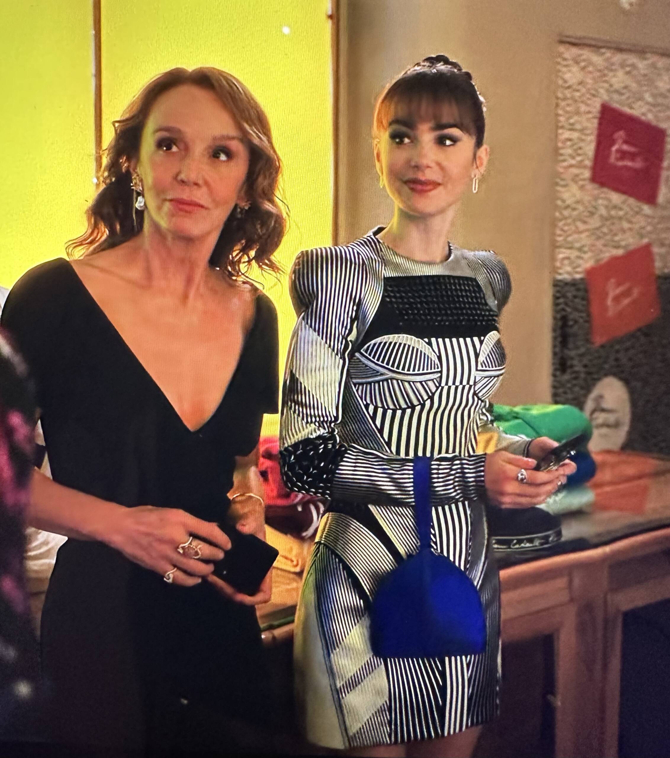 Emily in Paris Season 3 Episode 8, Lily Collins is wearing a black and white body con dress with a Renaud Pellegrino Cardinal Blue wristlet mini bag| Shop the fashion and bags of Emily in Paris Season 3