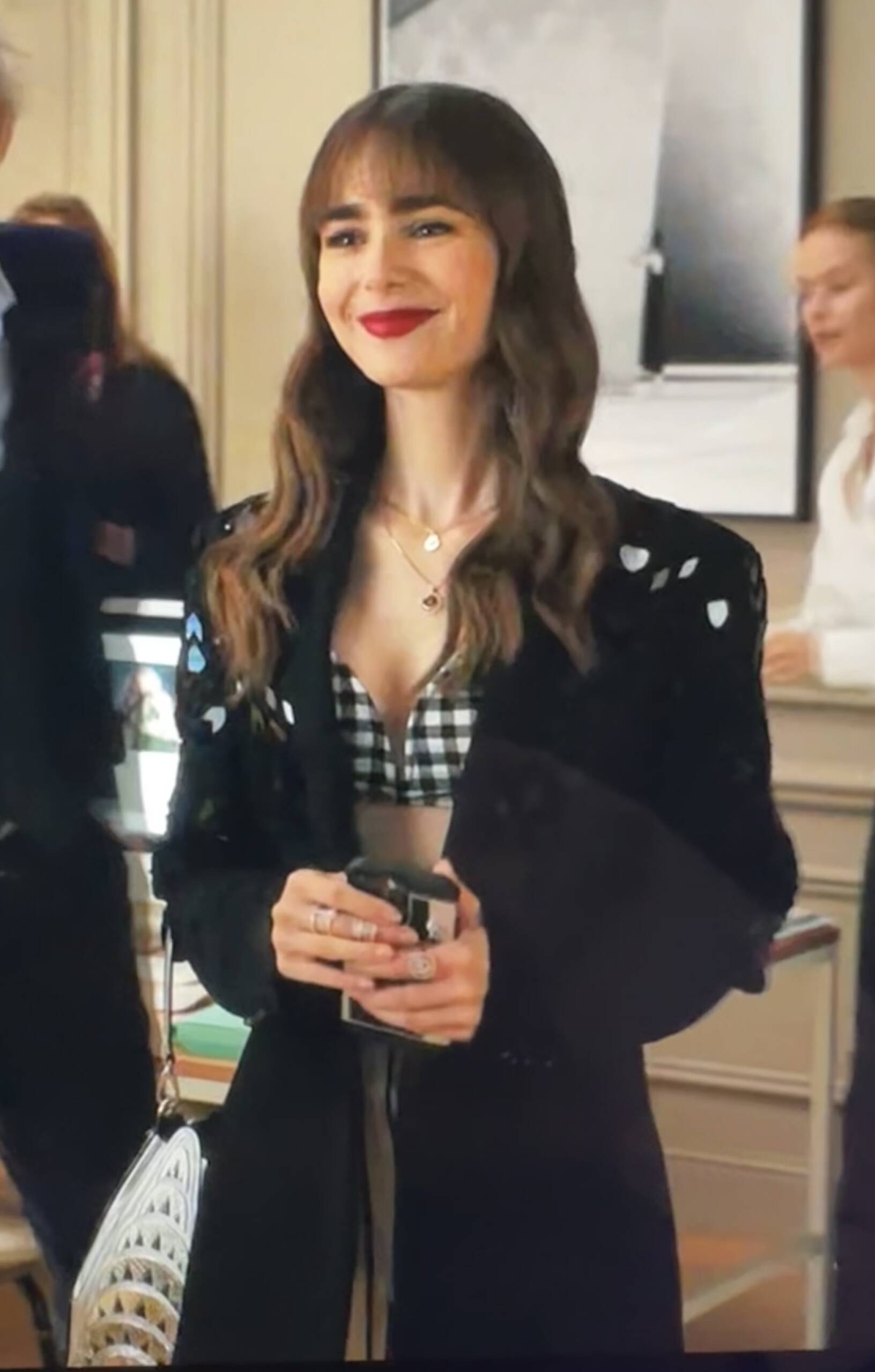 Emily in Paris Season 3 Episode 5 wearing a Barbara Bui Black blazer with a black and white gingham bandeau from Livy Studio with a silver building handbag in the crook of her arm. Nicolas Ghesquière designed the Louis Vuitton Minaudiere after the Chrysler Building in New York City in his 2020 collection.