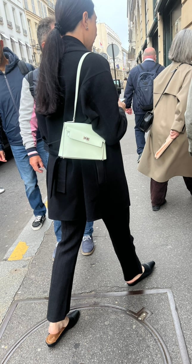 Woman carrying a Vert Fizz Hermès Kelly en Désordre outside Hermès Faubourg Saint-Honoré, Paris.