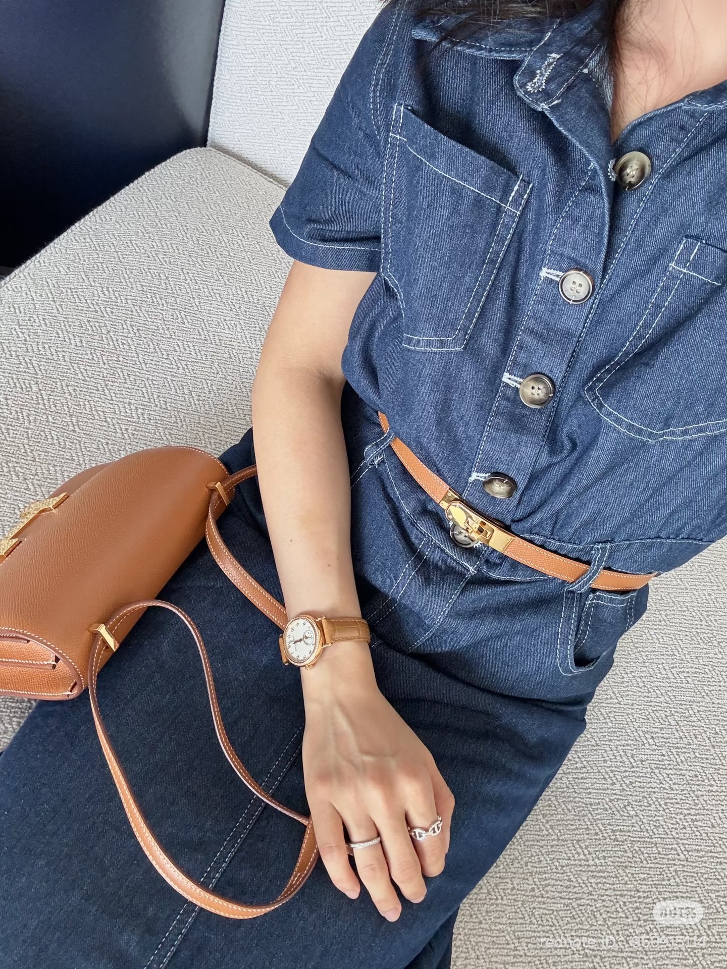 gold hermes kelly belt with gold hardware and gold hermes constance 18 wth gold hardware on woman in denim dress