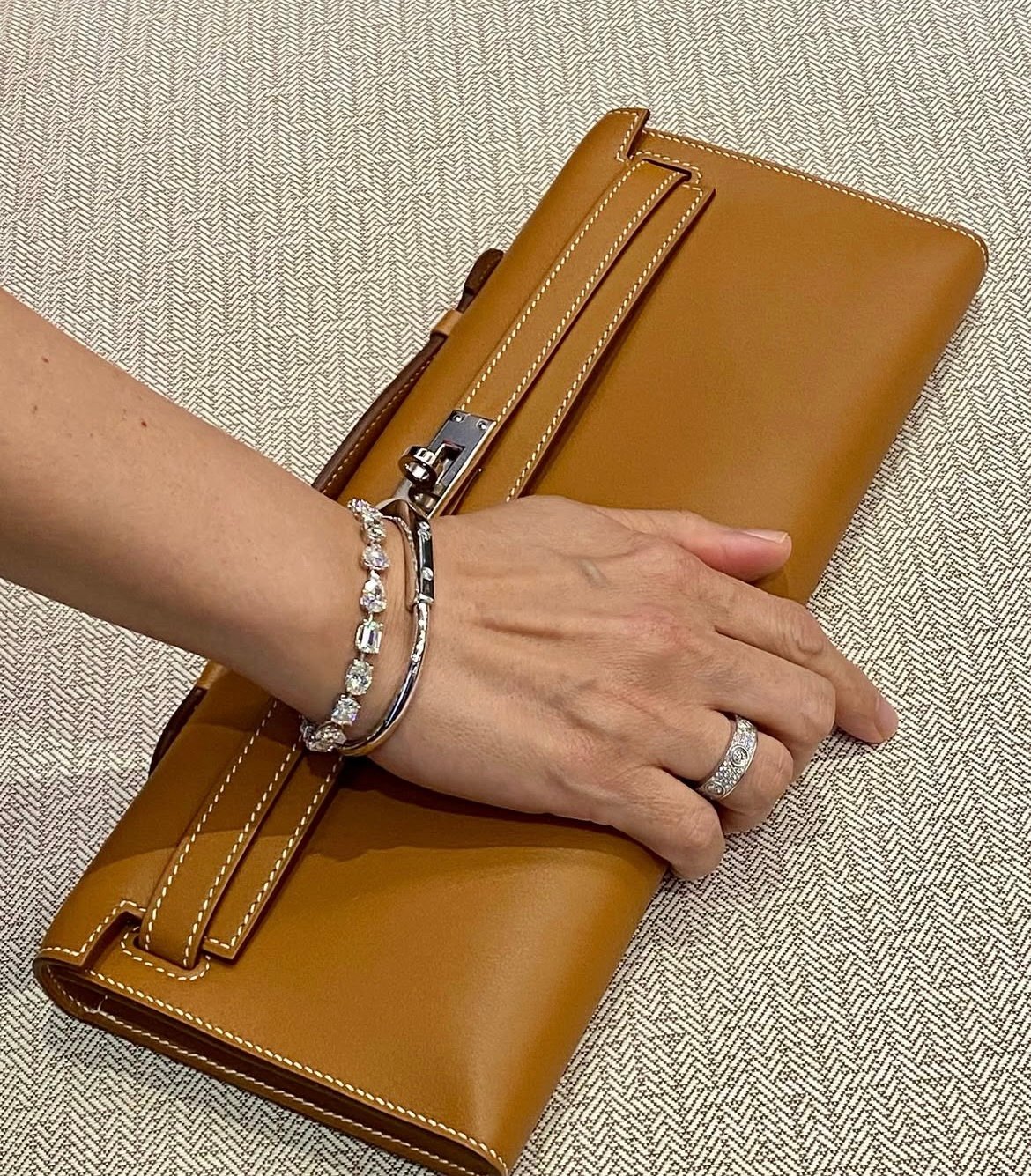 Hand holding a hermes gold kelly cut